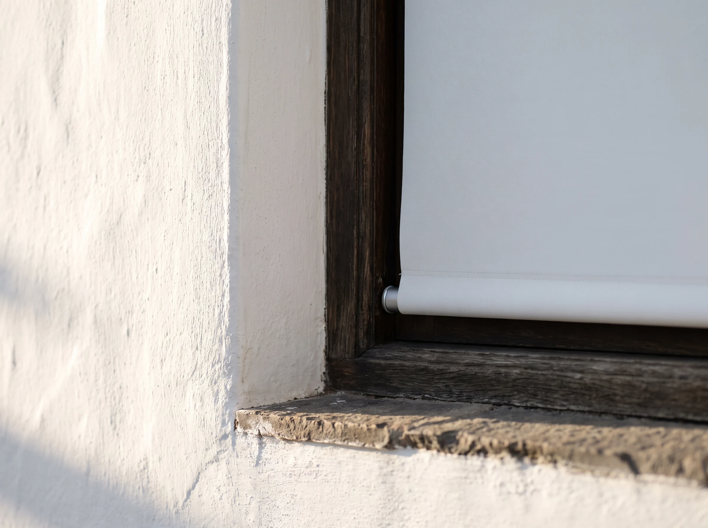 Close-up of a smooth flat blockout roller blind fabric edge against a whitewashed window reveal on a Groot Drakenstein homestead